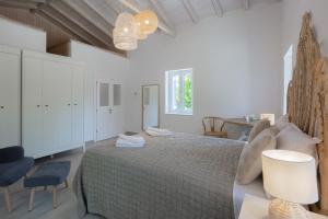 a white bedroom with a large bed and a table at Spacious House with Cottage&Pool in Nafplio +35 photos