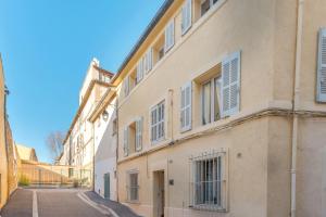 ein Gebäude mit Fensterläden auf einer Straße in der Unterkunft Lisse Studios in Aix-en-Provence