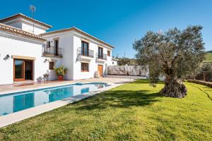 une villa avec une piscine et un arbre dans l'établissement Villa Antequera, à Malaga