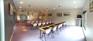una sala de conferencias con mesas y sillas. en Bremberg Hotel en Haasrode