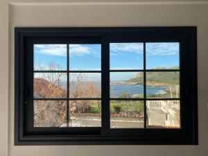 a window in a room with a view of the water at kipaki-trachila Mani in Trakhíla +35 photos