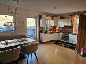 a kitchen with white cabinets and a table with chairs at Apart Sonnenblick in Landeck