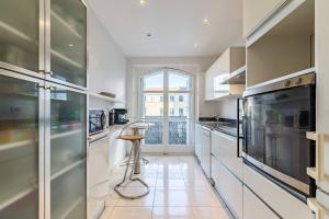 cocina con electrodomésticos blancos y ventana grande en Nadia By Terry's Homes, en Cannes