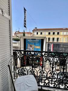 un balcón con una silla y un cartel en un edificio en Nadia By Terry's Homes, en Cannes