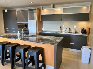 a kitchen with a counter and some black cabinets at Lakeview Apartment in Taupo