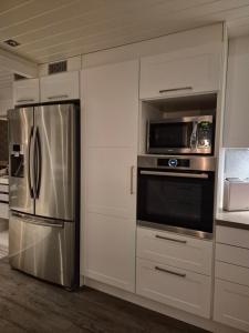 a kitchen with a stainless steel refrigerator and microwave at Familievennlig rekkehus in Tromsø
