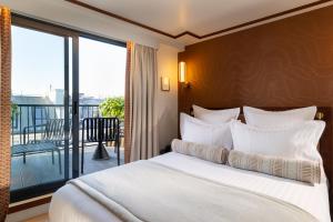 a bedroom with a large bed and a balcony at Hôtel Filigrane & Spa in Paris
