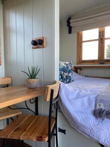 a bedroom with a bed and a wooden table and a desk at The Hide at Manton Bay- Glamping in Oakham