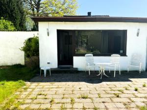 une table et des chaises devant une maison blanche dans l'établissement Haus 15-20P - 8Zi - Aurora Hamburg, à Hambourg