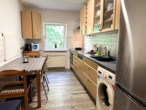 La cuisine est équipée d'une table, d'un évier et d'un lave-vaisselle. dans l'établissement Haus 15-20P - 8Zi - Aurora Hamburg, à Hambourg 8 autres photos