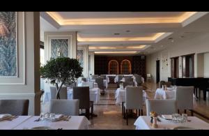 a dining room with white tables and chairs at The Yalı Konak Hotel İzmir in İzmir