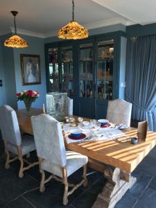 a dining room with a wooden table and chairs at Mevagissey Boutique Flatlet with sea and countryside views in Mevagissey +26 photos