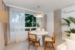 un comedor con una mesa y sillas blancas y una ventana en MONKÓ LUXURy EGYPT, en Torremolinos