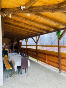 a patio with a table and chairs and a wooden ceiling at Best Vila Valea Avrigului in Avrig
