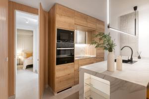 Una cocina con una gran pared de madera con microondas. en MONKÓ LUXURy EGYPT, en Torremolinos 27 fotos más
