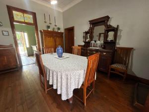 a dining room with a table with a blue vase on it at Wooden Door Guesthouse in Brits