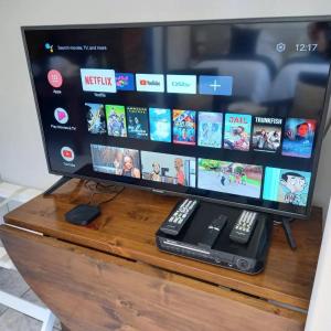 a flat screen tv sitting on top of a wooden table at Den-Away Guesthouse Self Catering Middelburg Mpumalanga in Mhluzi
