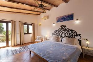 a bedroom with a large bed with a blue comforter at Finca Son Marimon - Adults Only in Santanyi +135 photos