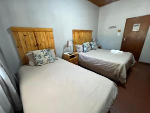 two beds in a small room withermottermottermott at Wooden Door Guesthouse in Brits