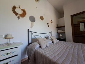 a bedroom with a bed and a dresser and a mirror at Agriturismo Lu Nodu in Greuli  +28 photos