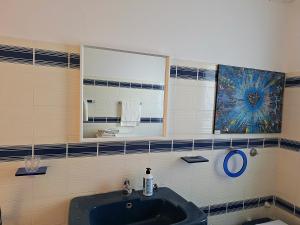 een badkamer met een wastafel en een spiegel bij CasaWhite in San Vito Chietino +5 foto's