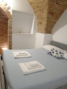 una camera da letto con un letto con due asciugamani sopra di GiuattyHomeHolidayTermoli2 a Termoli