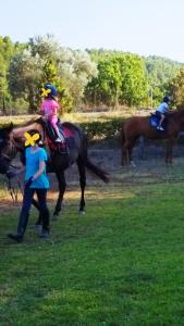 een groep mensen die op de ruggen van paarden rijden bij Armonia Elegant Apartments in Rovies