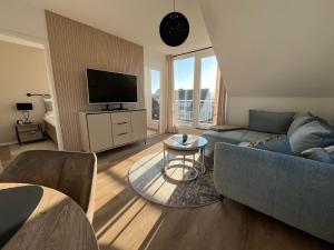 a living room with a couch and a tv at Ostsee-AuszeitDahme in Dahme
