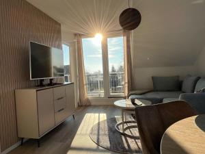 a living room with a couch and a tv at Ostsee-AuszeitDahme in Dahme