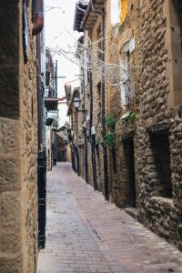 an empty alley with stone buildings and a brick street at Número 8 a Traditional Basque Village Homestead in Laguardia