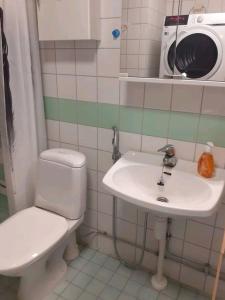 a bathroom with a toilet and a sink and a microwave at Stylish city center home with sauna in Rovaniemi
