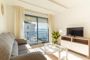 a living room with a couch and a large window at Apartamentos Punta Lucero en Portonovo in Portonovo