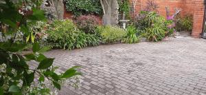a brick walkway with flowers and plants on it at Little Gem in Plettenberg Bay +1 photo