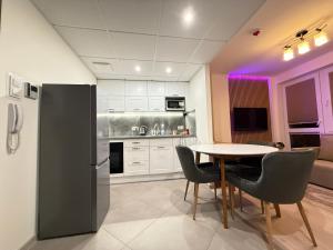 a kitchen with a table and chairs and a refrigerator at Warsaw Smart Apartment with Parking in Warsaw