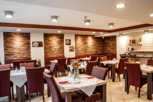 a restaurant with tables and chairs in a room at Hotel Central eGbR in Würzburg
