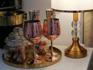 two wine glasses on a table next to a lamp at Amour majestique in Paris