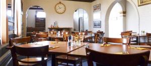 RailtonRailton Hotel - heritage pub accommodation的一家有桌椅和挂钟的餐厅