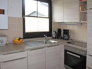 une cuisine avec un évier et une fenêtre dans l'établissement Ferienhaus Nr 33, Kategorie Komfort, Feriendorf Hochbergle, Allgäu, à Lechbruck am See