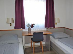 une chambre avec deux lits, un bureau et une fenêtre dans l'établissement Ferienhaus Nr 33, Kategorie Komfort, Feriendorf Hochbergle, Allgäu, à Lechbruck am See 11 autres photos