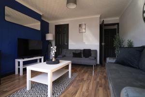 a living room with a couch and a table at Sauchie House in Sauchie