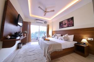 瑞诗凯诗Perfectstayz Value Forest Valley Rishikesh的一间卧室，里面有一张床和一扇大窗户。