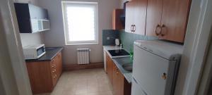 a kitchen with a white refrigerator and wooden cabinets at Noclegi Włocławek in Włocławek