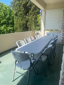 a long table and chairs on a patio with at Bergerac- Grande maison familiale, terrasse, jardin in Bergerac +45 photos