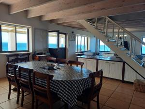 a kitchen and dining room with a table and chairs at Whale Watch Cottage in St Helena Bay +13 photos