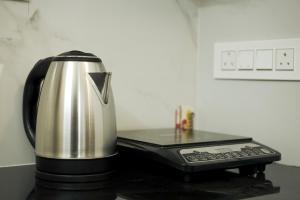 a coffee pot sitting next to a cell phone at Filza Residency in Cochin
