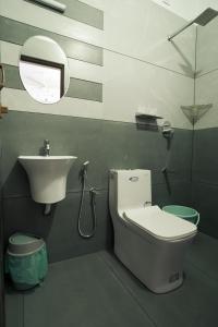 a bathroom with a sink and a toilet and a mirror at Filza Residency in Cochin +17 photos