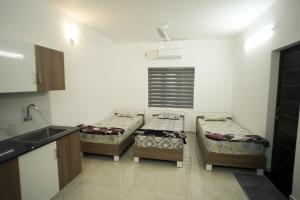 a room with two beds and a sink in it at Filza Residency in Cochin