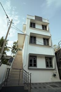a white building with stairs leading up to it at Filza Residency in Ernakulam +17 photos