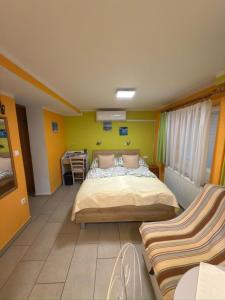 a bedroom with a bed and a couch in it at Sobe- Rooms - Apartments - Free parking! in Maribor