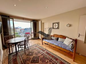 a living room with a couch and a table at Le Boyard - En plein coeur de ville avec vue sur l'Océan in Fouras